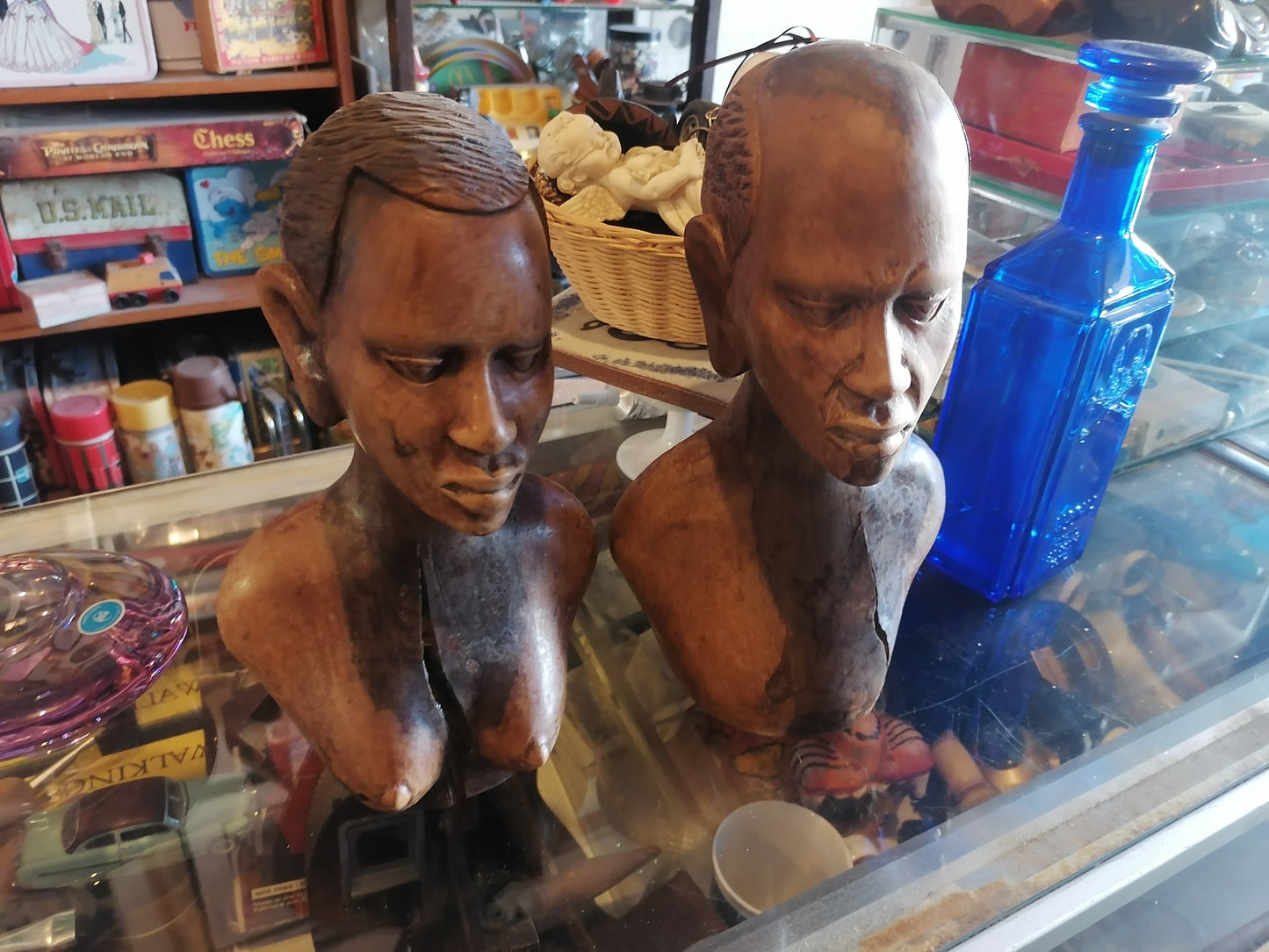 Par de bustos tallados en madera, representando a un hombre y una mujer, de origen africano - Antiques Bazaar Ensenada